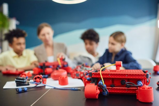 Crianças trabalham juntas na construção de um projeto de robótica em uma atividade educativa